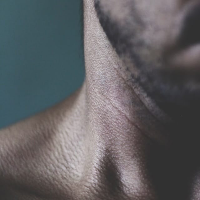 A guy feeling skin irritation because of a mouth tape